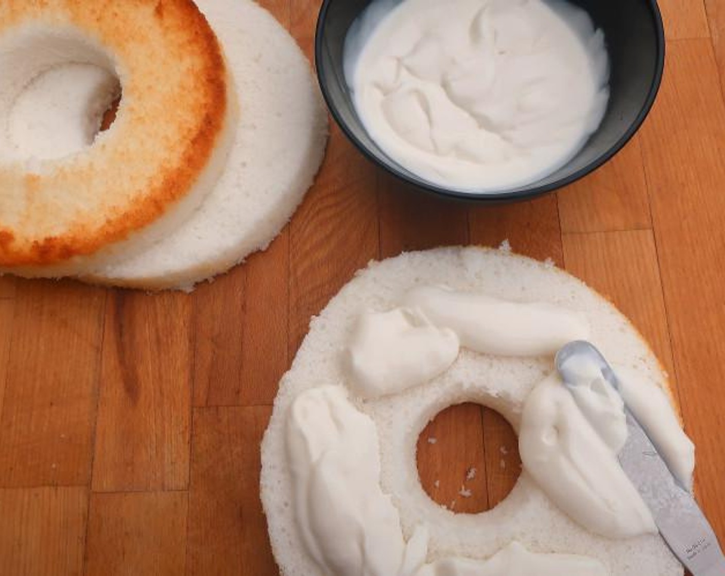 step 3 Divide 2 cups of vanilla cream between the bottom-two of the rings, re-assemble the cake.