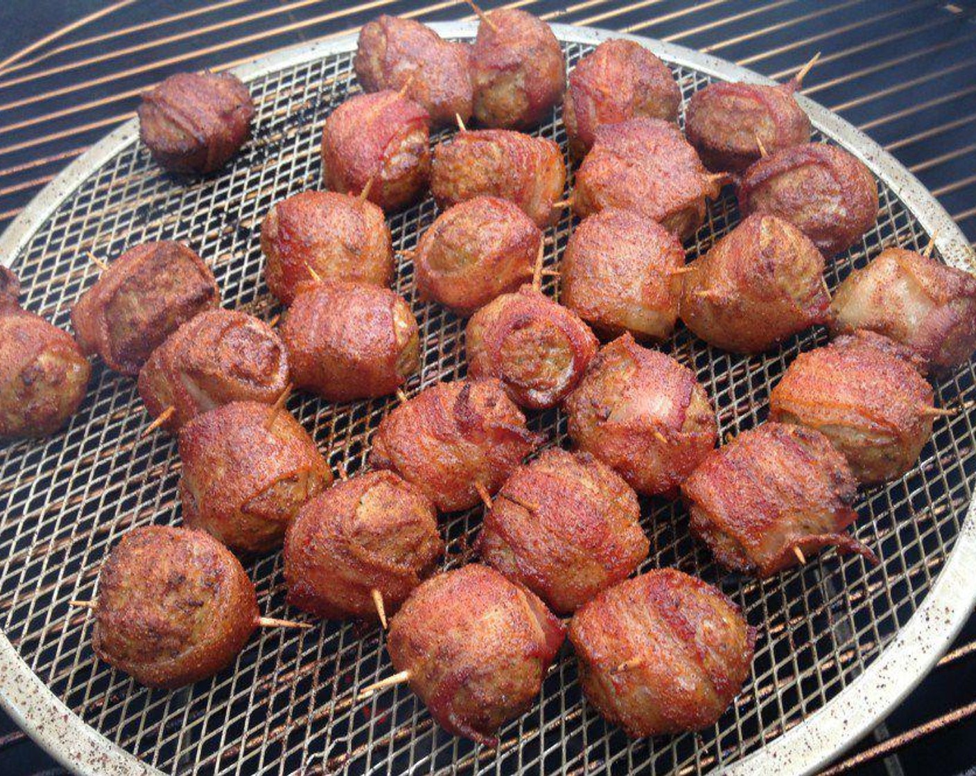 step 3 Get your smoker or grill set at 275 degrees F (140 degrees C) and place these bacon-wrapped meatballs on the cooker. Cook until the bacon has a great, mahogany color, about 1 – 1.5 hours. Check them after 45 minutes to keep an eye on the color and turn them if needed.