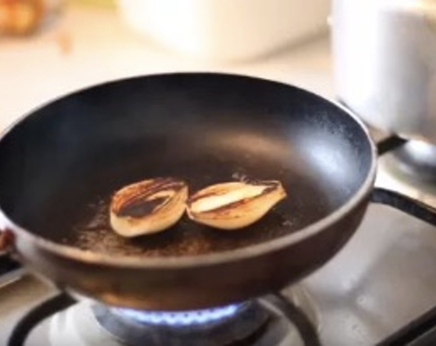 step 8 For the garnish, slice the White Onion (1) in half, place it into a hot pan and press it down until it browns. Cook until soft.