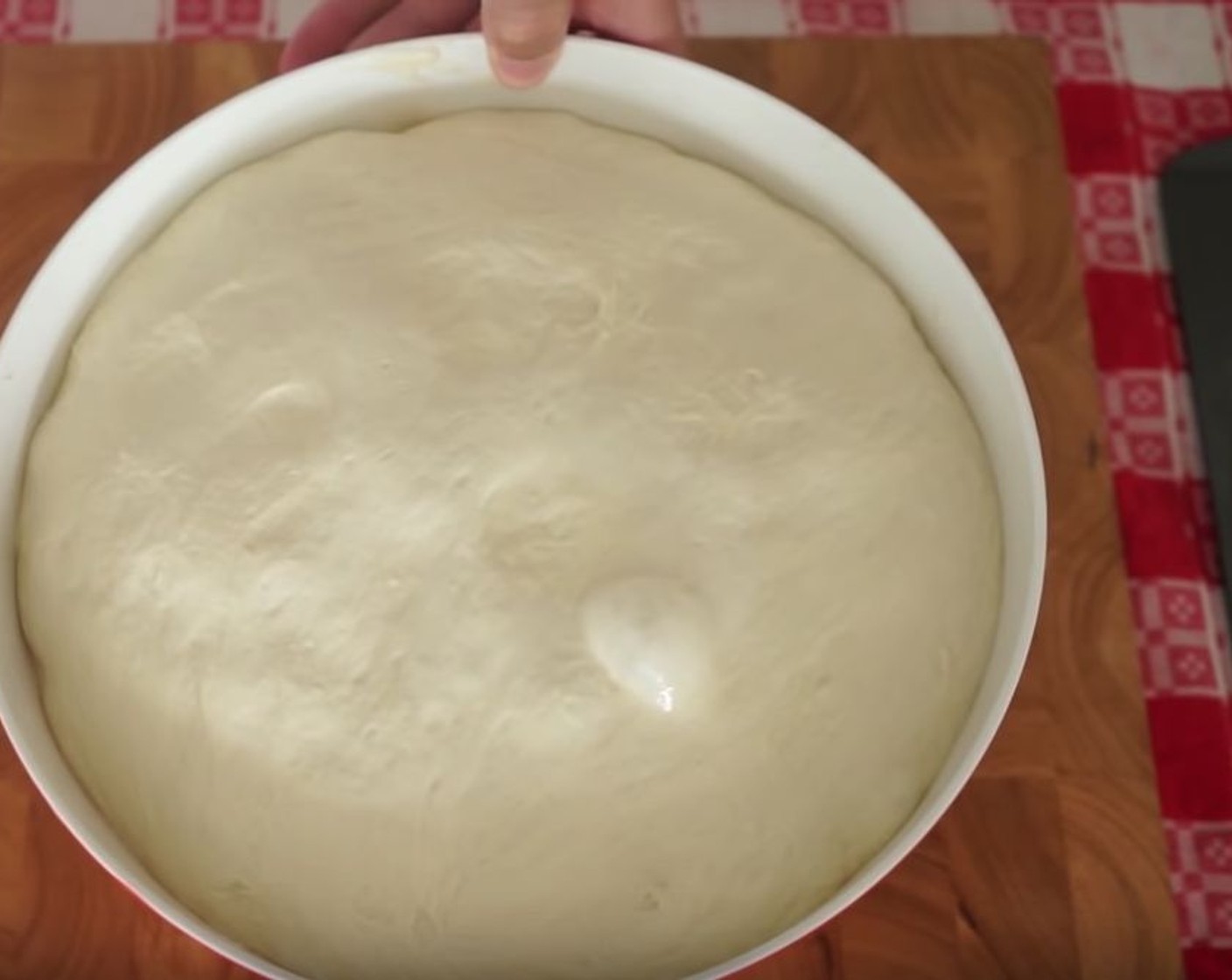 step 6 Remove the dough from the bowl and place it on a chopping board. Stretch it out, then cut it in half.