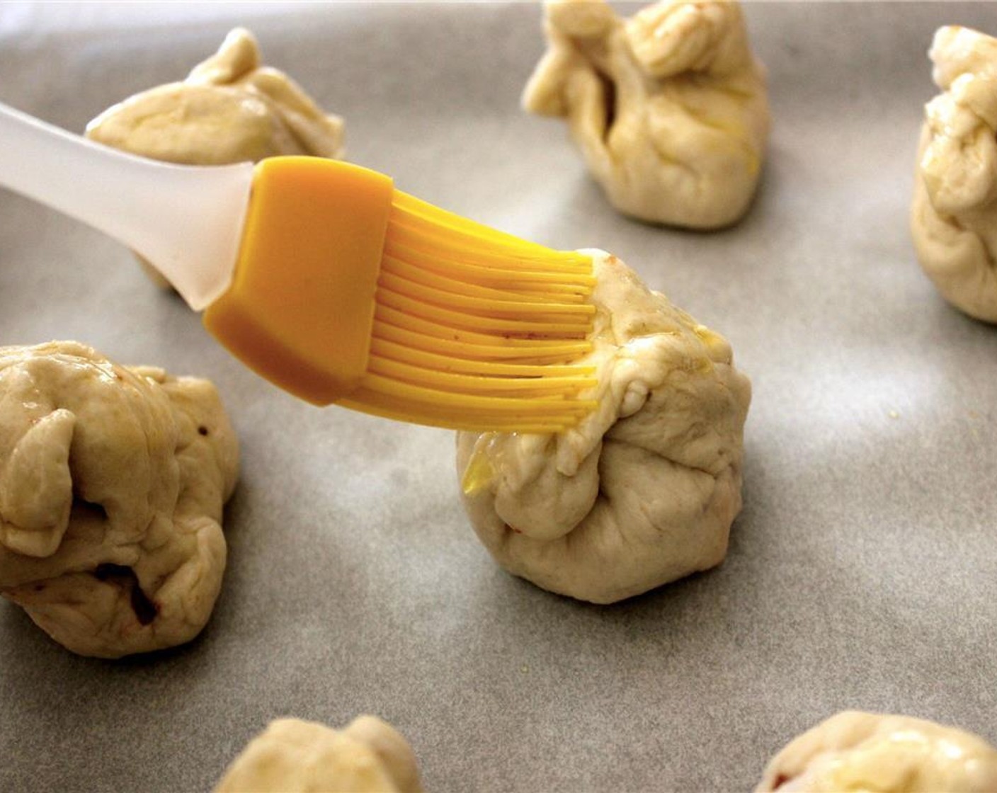 step 3 Seal the dough, and shape the excess dough into a knot on top. Brush the tops with Olive Oil (as needed) or bacon grease.