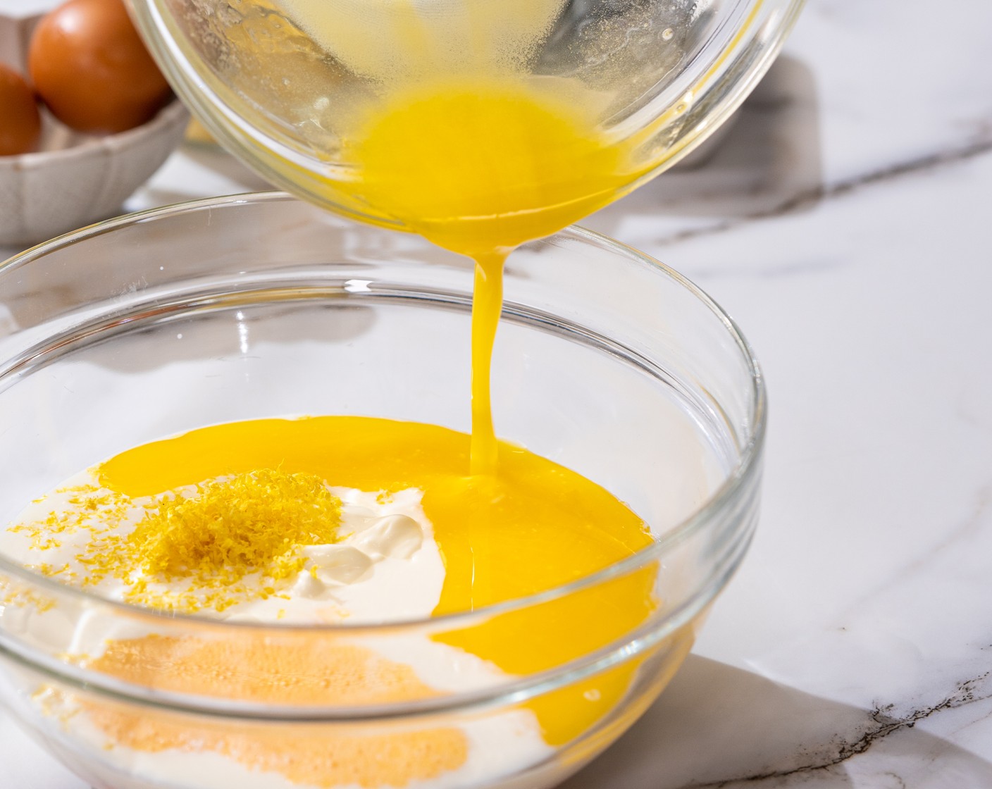 step 3 In another bowl, whisk together Greek Yogurt (1 cup), Milk (1/2 cup), Granulated Sugar (1/3 cup), Lemon (1), Eggland's Best Classic Eggs (2), and Butter (1/3 cup).