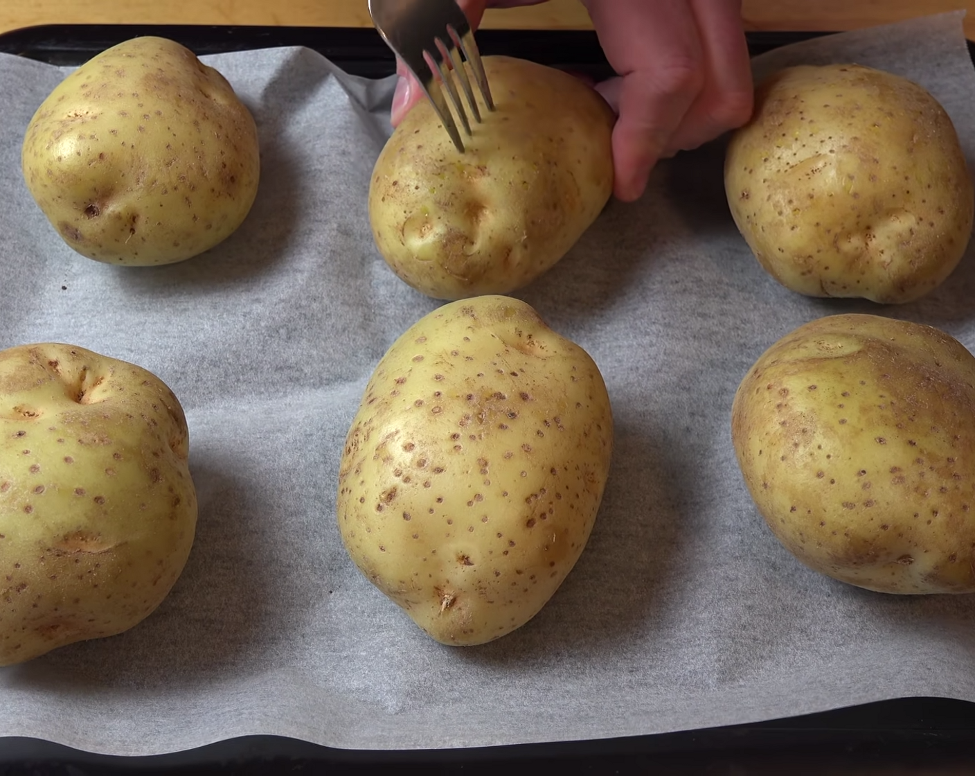 step 4 Place your Potatoes (4.4 lb) in a parchment-lined baking pan. Using a fork, make prick marks on both surface sides of each potato. The vent holes help the steam to escape whilst baking the potatoes.