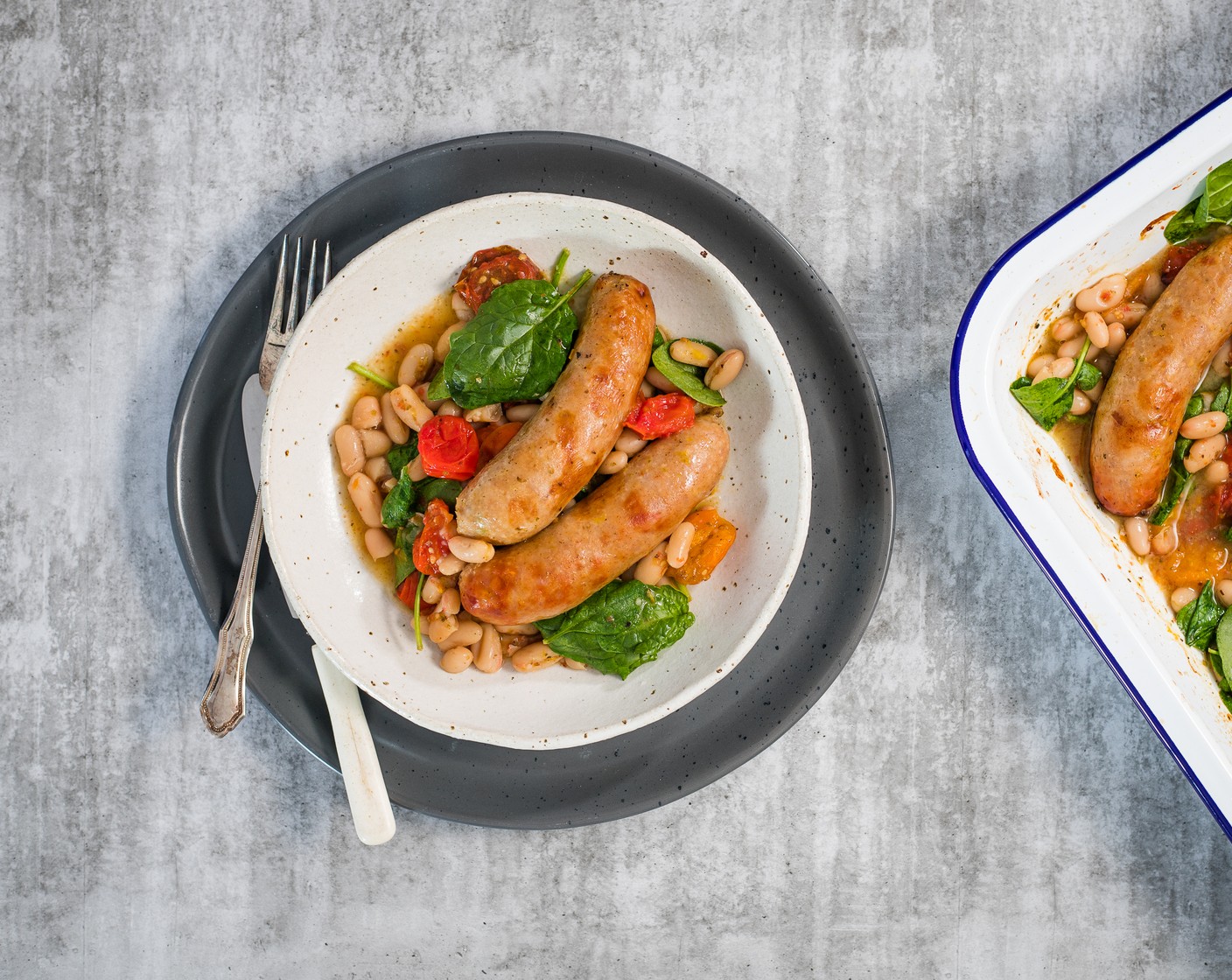 step 5 Remove from the oven, scoop the tomato-bean mixture onto warmed plates and top with sausages. Serve immediately.