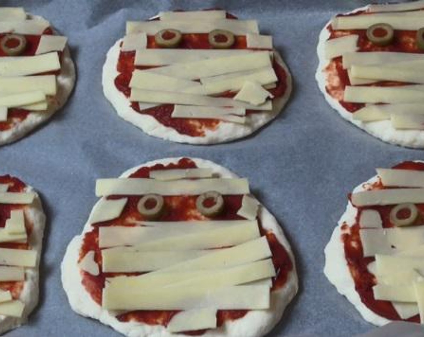 step 3 Divide the dough into 6 roughly equal pieces, and form each piece into a nice round pizza base. Then on top of each piece, add your Tomato Paste (to taste), Green Olives (to taste), and Cheddar Cheese (to taste). Bake inside a preheated oven under 180 degrees C (350 degrees F) for about 15 minutes.