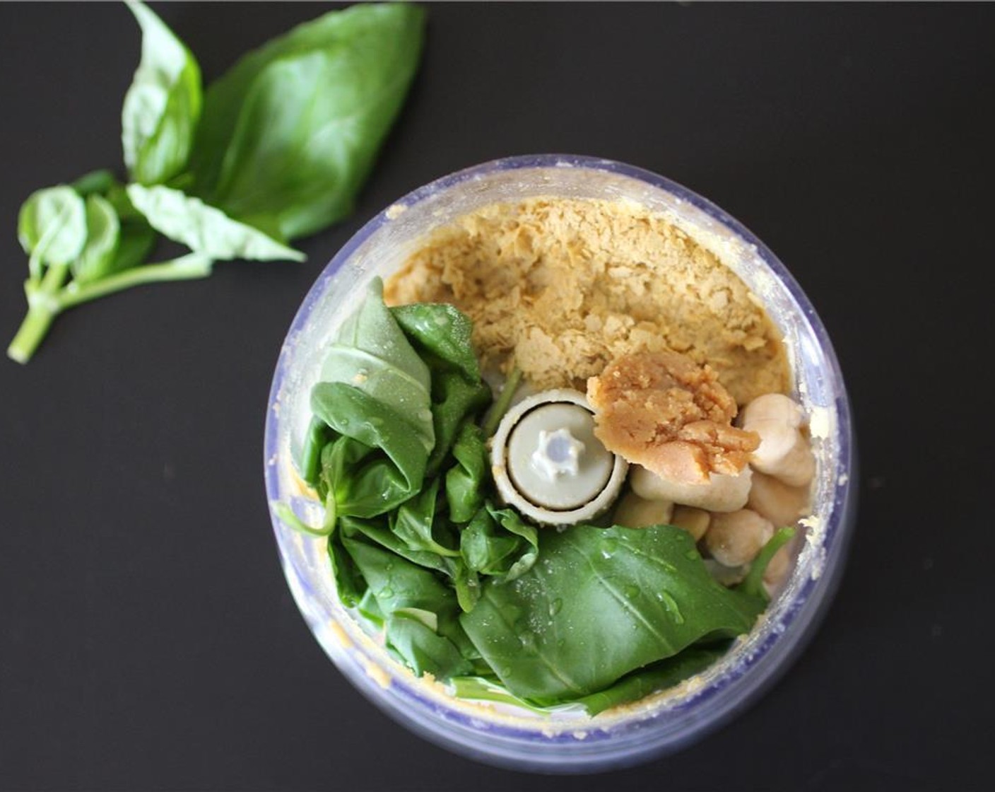 step 2 Add the Fresh Basil (1/2 cup), drained cashews, Garlic (1 clove), Nutritional Yeast (1/4 cup), White Miso Paste (1/2 Tbsp), Water (1 Tbsp), juice from Lemon (1) and Salt (1 pinch) to a food processor.