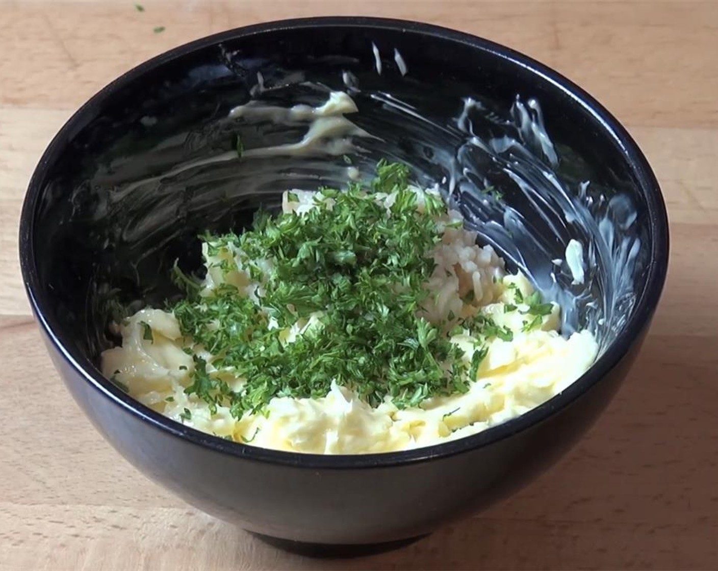 step 2 In a bowl, add the Butter (4.5 oz), Garlic (2 cloves), and Fresh Parsley (1 handful). Mix everything together until smooth.