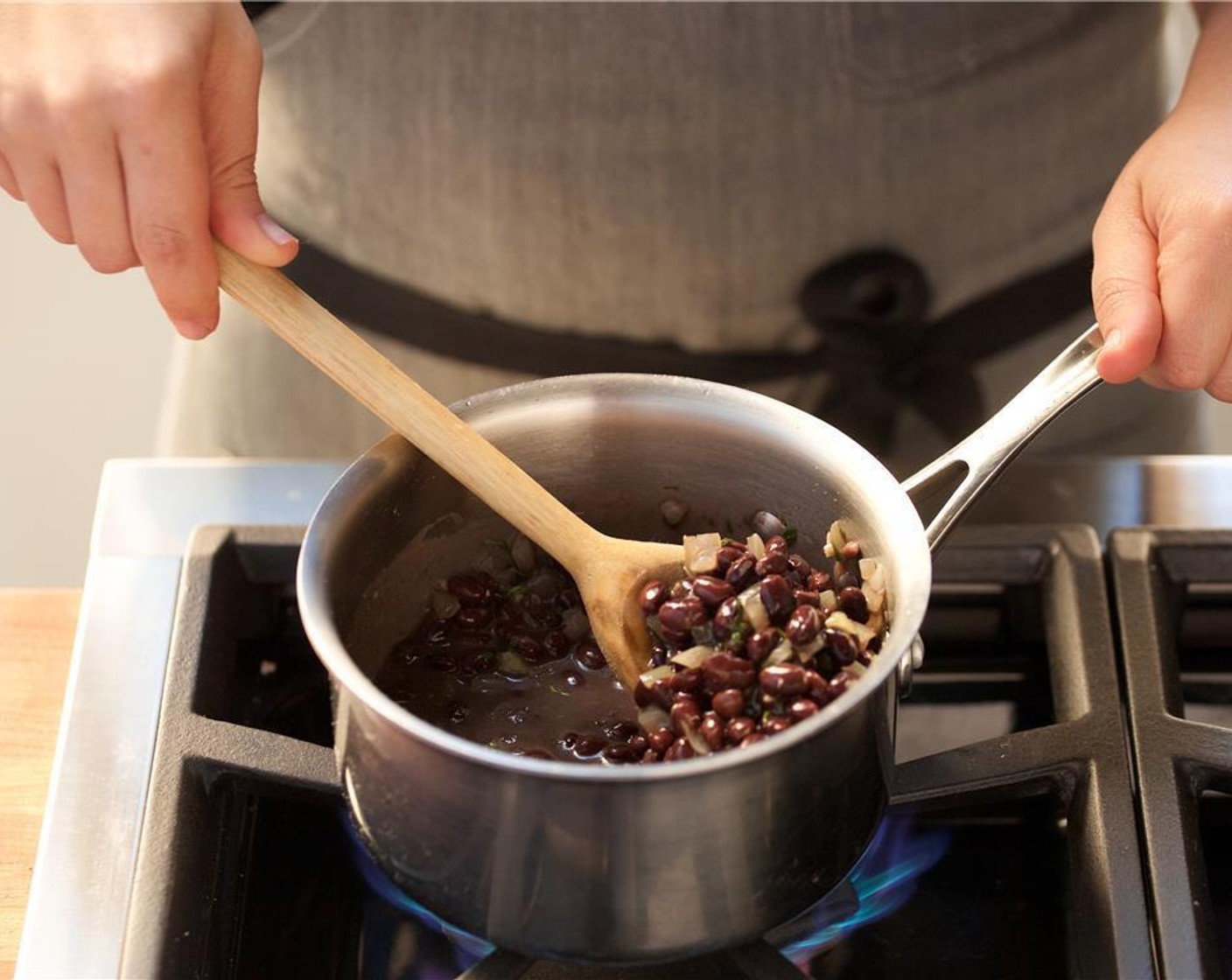 step 5 In a small saucepan over medium heat add Olive Oil (1/2 Tbsp). When hot, add half of the garlic and onions and cook for two minutes until soft and translucent.