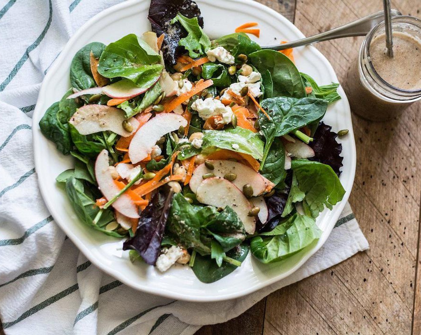 step 2 For the Salad: Divide Fresh Spinach (4 cups), Carrot (1), Apple (1), Canned Chickpeas (1/4 cup), Goat Cheese (4 Tbsp) and Pepitas (2 Tbsp) into two large plates or bowls, drizzle with dressing, serve and enjoy.