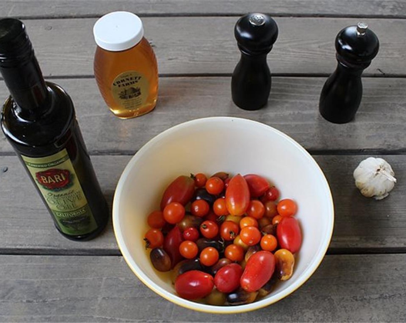 step 2 Cut Cherry Tomato (1 pckg) in half and arrange on an oiled roasting pan.