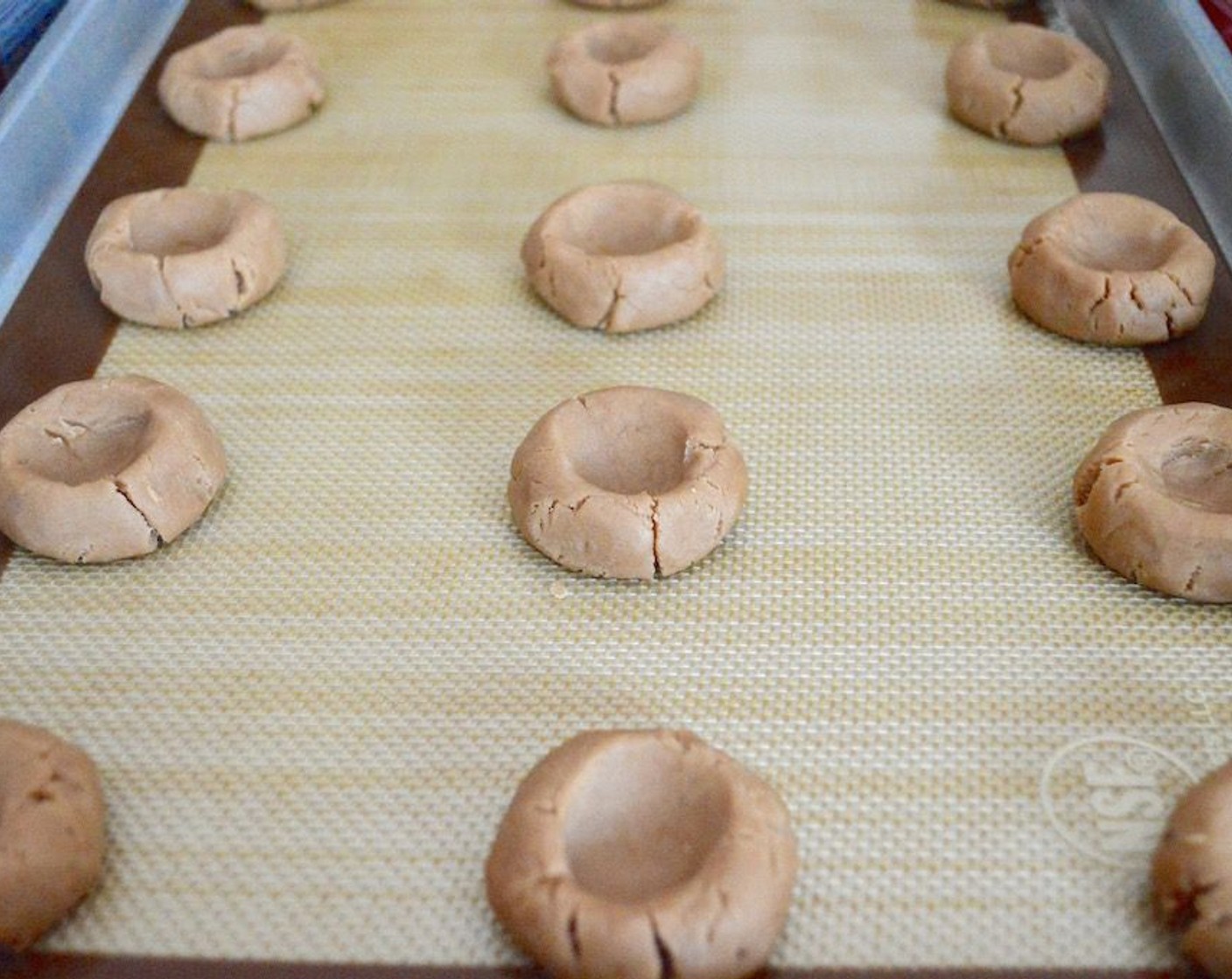 step 7 Use your thumb to make a big indentation in the center of each ball of dough, then put the trays in the refrigerator to chill for an hour.