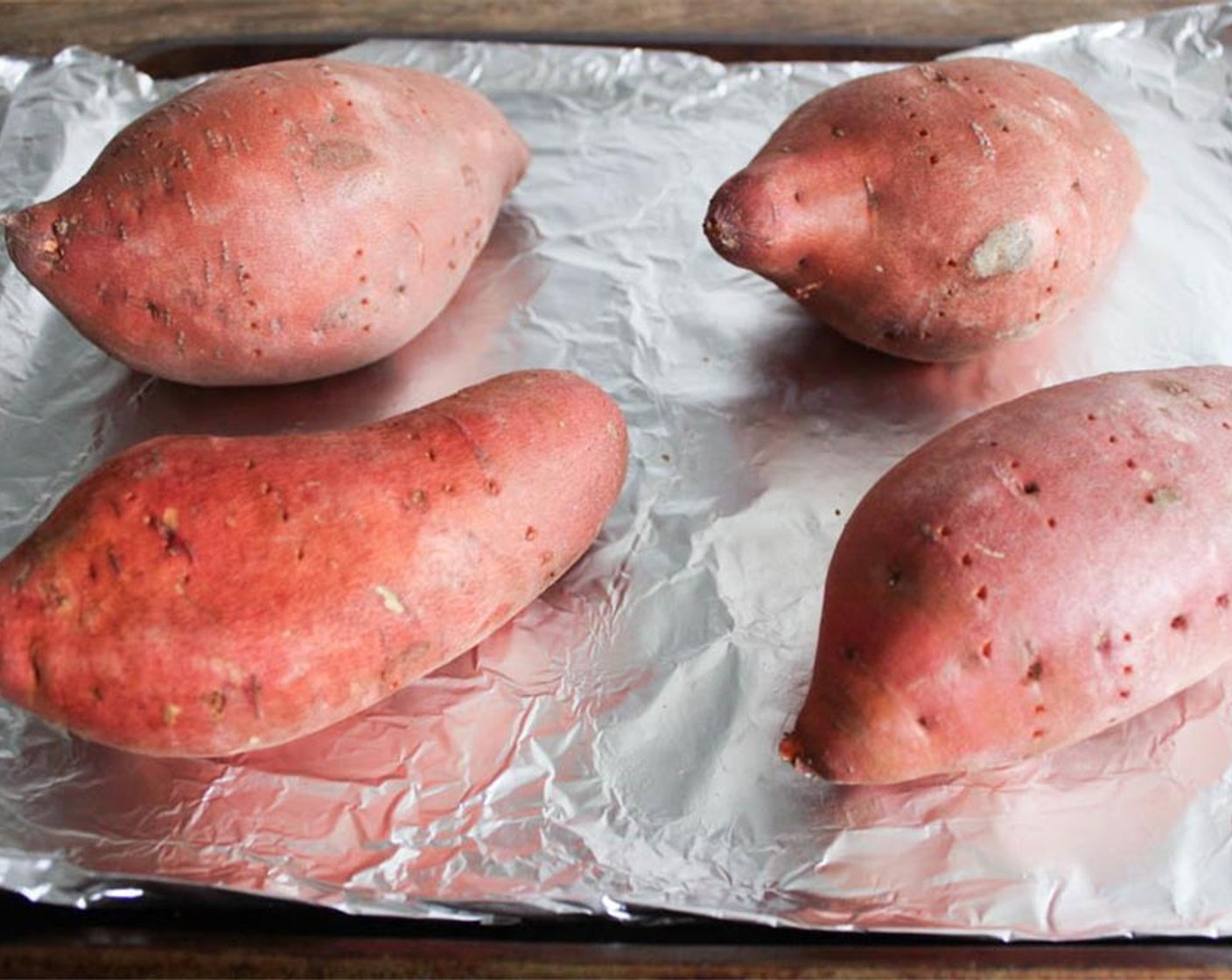 step 2 Wash the Sweet Potatoes (4) and dry them well. Use a fork to carefully poke holes all over the sweet potatoes, about 2 fork pokes per side should do it, and place the sweet potatoes on the baking sheet.