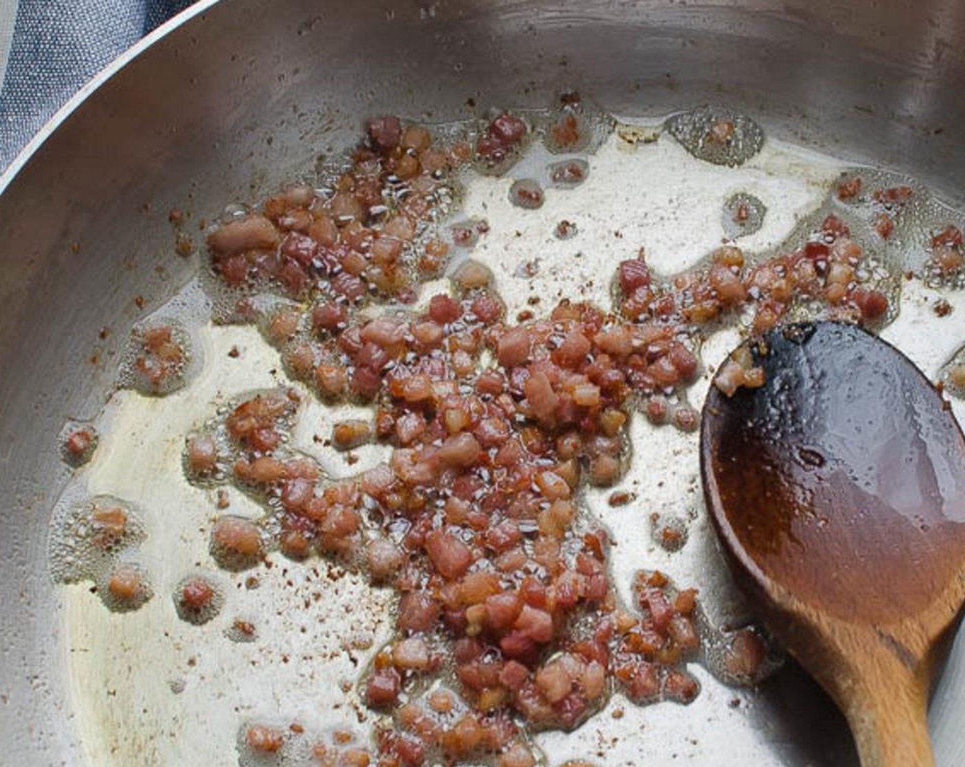 step 2 In a large skillet, heat the Olive Oil (1 Tbsp) over medium high heat. Add the Pancetta (1/4 cup) and cook until it has rendered some fat and started to crisp. Use a slotted spoon to transfer the pancetta to a small bowl.