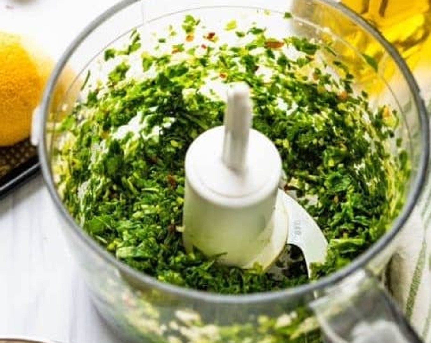 step 6 Roughly chop the Garlic (3 cloves) and transfer it to a mini prep food processor. Add the Fresh Basil Leaves (3 cups), Kosher Salt (1/2 tsp), Lemon (1/2 tsp), and Crushed Red Pepper Flakes (1/2 tsp). Pulse several times, scraping down the sides as necessary until the basil is finely chopped.