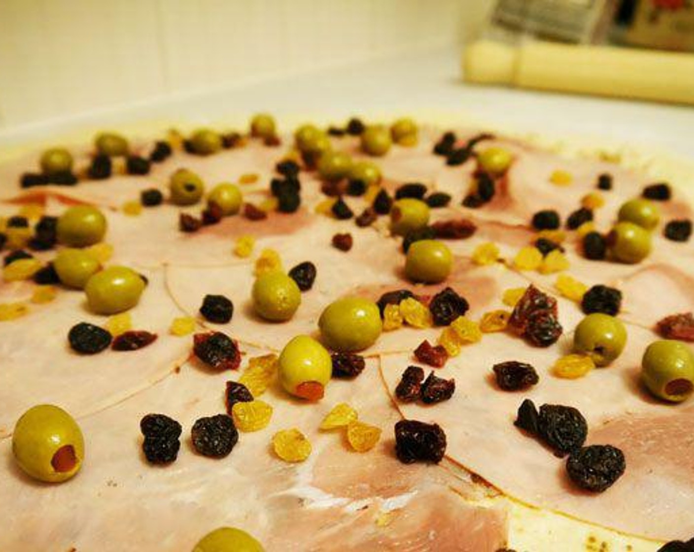 step 6 Place a layer of Prosciutto (9 oz), then a layer of Raisins (1/2 cup) and finish with a layer of the Pitted Green Olives (1 cup).