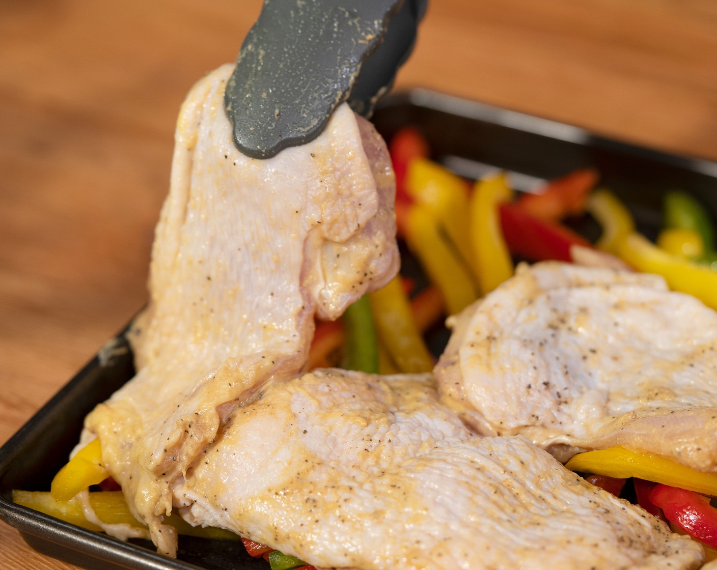 step 4 Place the bell peppers into the baking sheet. Place the chicken thigh skin side up over the bell peppers. Bake until golden and the internal temperature reaches 165 degrees F (74 degrees C), about 15 minutes.