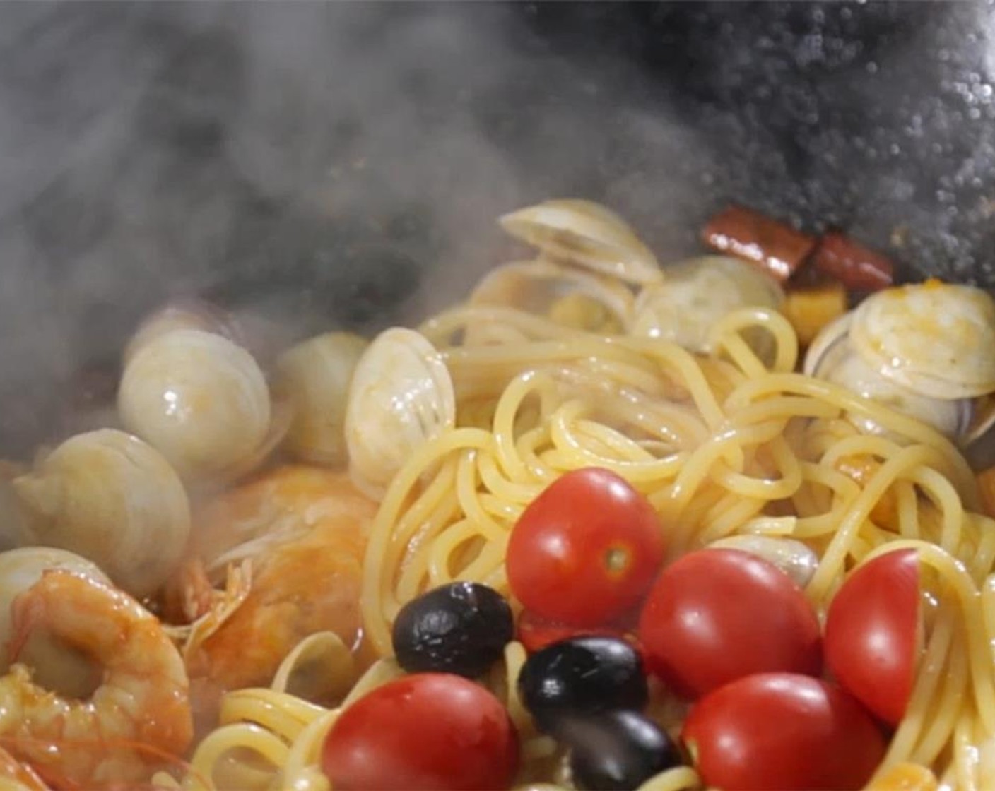 step 5 Then stir in cooked spaghetti, cherry tomatoes and Black Olives (2 Tbsp), shrimp and clam. Toss everything together and cook for an additional minute.