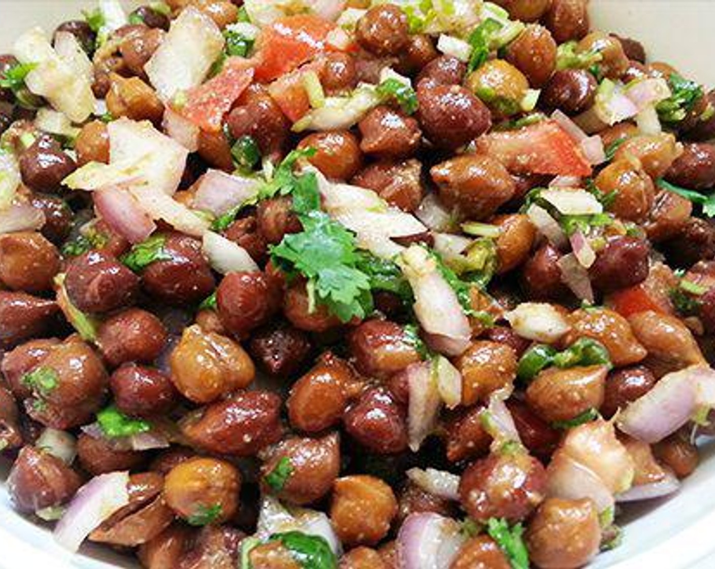 step 3 To the cooked chickpea, add onion, green chili, tomato, Olive Oil (1 Tbsp), coriander, juice from Lime (1/2), Ground Cumin (1 tsp), and Salt (to taste). Combine well and serve.