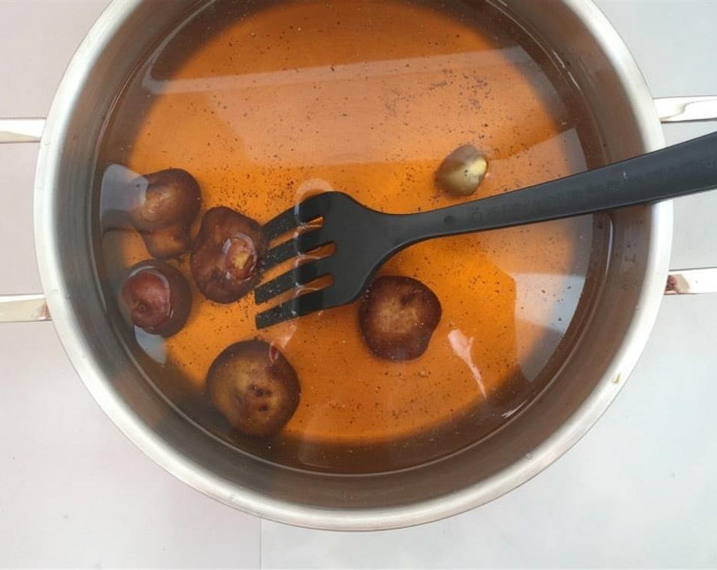 step 1 Pour the Water (3 cups) and the Beer (2 cups) in a large pan and add the Garlic (1 clove), Potatoes (6), a dash of Ground Black Pepper (to taste), and Old Bay® Seasoning (2 Tbsp).