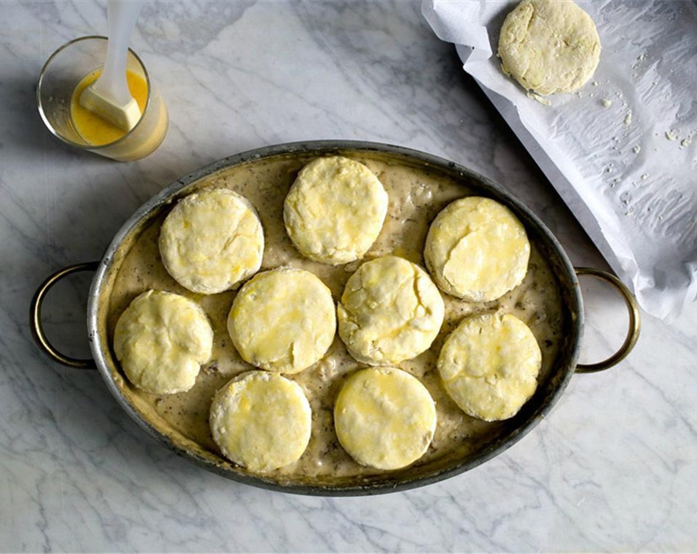 step 17 Arrange the frozen biscuits over the gravy, and brush the top with egg wash. Bake in the oven for 10 min.