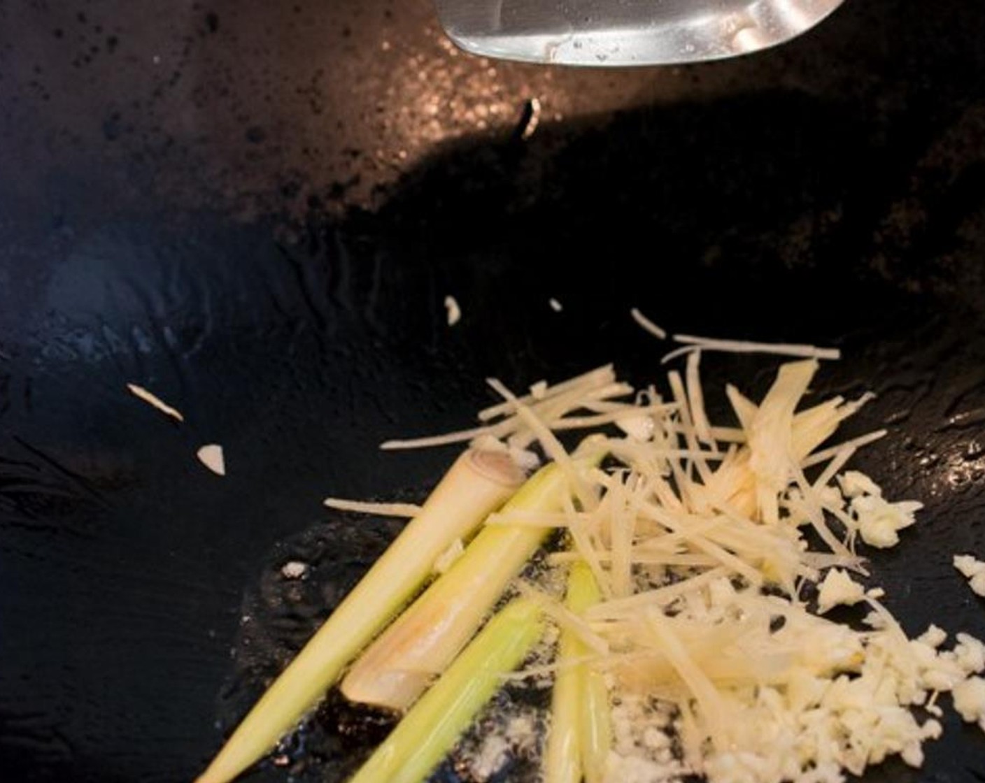 step 3 Heat up Cooking Oil (3 Tbsp)ng oil (3 tablespoon) over medium-heat in a wok or large frying pan. Cut the Lemongrass (2 stalks) into 4 pieces and stir-fry until the edges start to brown just a little.