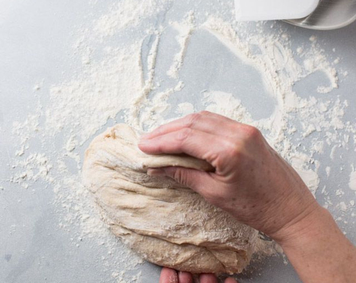 step 6 When the dough has risen, liberally flour your work surface and gently transfer your dough to the surface with a spatula. It is a moist dough, so you'll want to flour your hands too. Fold the dough in half like a taco. Then fold in half the opposite sides. Fold in half 2 more times.