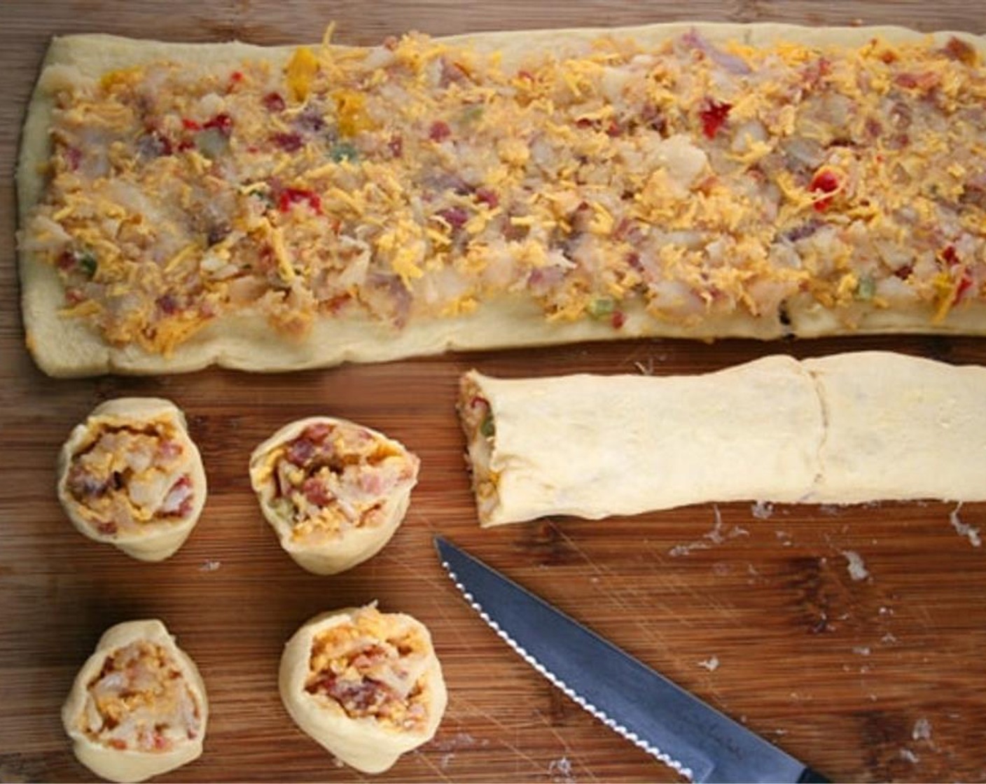 step 6 Spread half of the potato mixture on one rectangle to within 1/4-inch of long edges. Starting at one long side, tightly roll up dough; pinch seams to seal. Using serrated knife, cut roll into 14 slices. Place slices, cut side up, on cookie sheets.