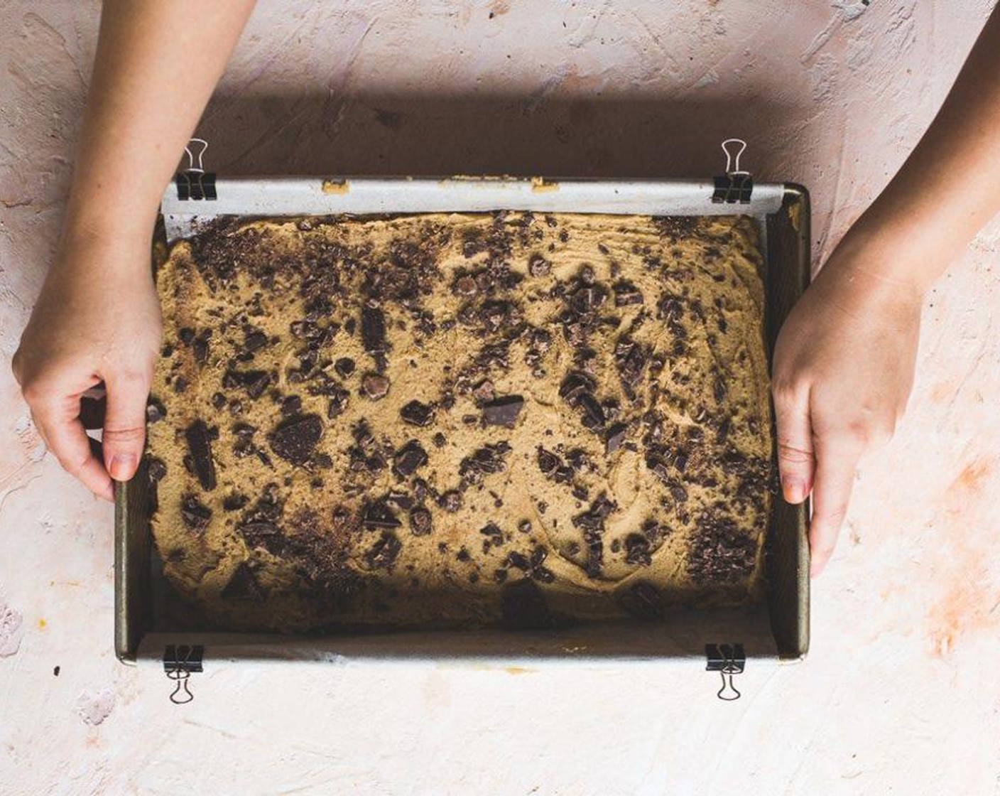 step 6 Scoop out half of the dough all around the pan and smooth out as best as possible. Scoop out the Nutella® (1 cup) and smooth across the dough evenly. Repeat with the top layer of batter. Sprinkle the Chocolate (1 bar) on top. Place in the oven for 20-25 minutes.