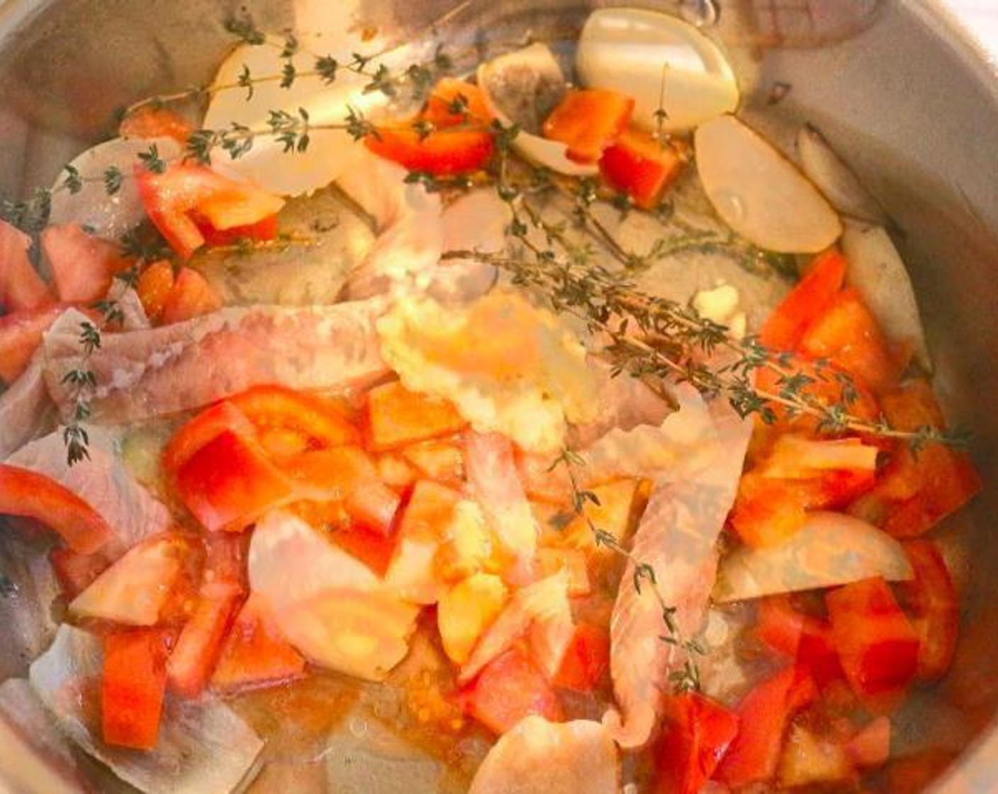 step 3 In a stock pot, heat Extra-Virgin Olive Oil (1/2 cup) and saute Onion (1). Add the fish trimmings, shrimp shells, half the Tomato (1) and Fresh Thyme (3 sprigs).