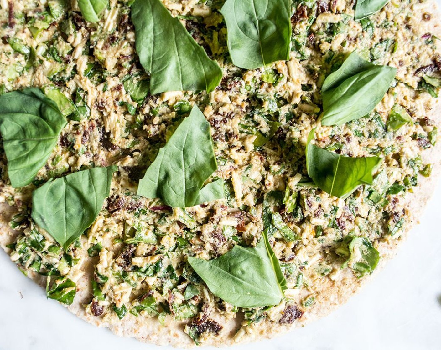 step 3 Lay out Tortillas (4), divide cheese/pesto/tomato mixture evenly among the four tortillas, spreading in a thin layer until it coats the whole tortilla up to the outer edge. Tear and sprinkle approximately 5 Fresh Basil Leaves (20) over each tortilla.