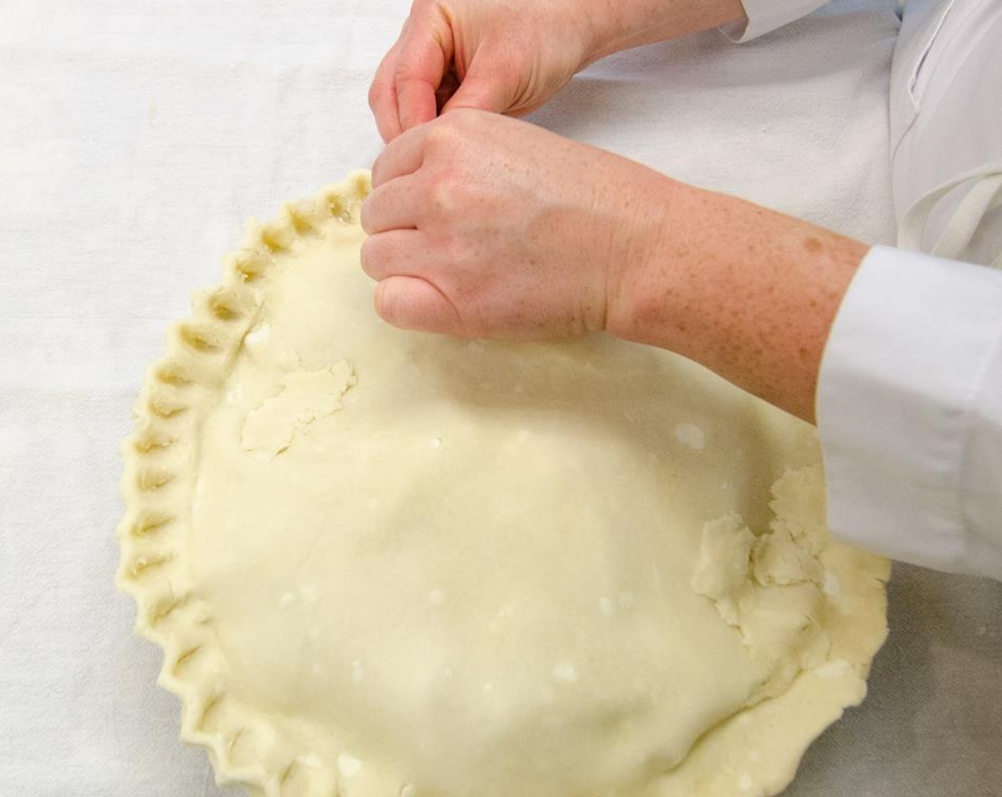 step 23 Tuck overhanging dough beneath itself. Flute or crimp with a fork to seal.