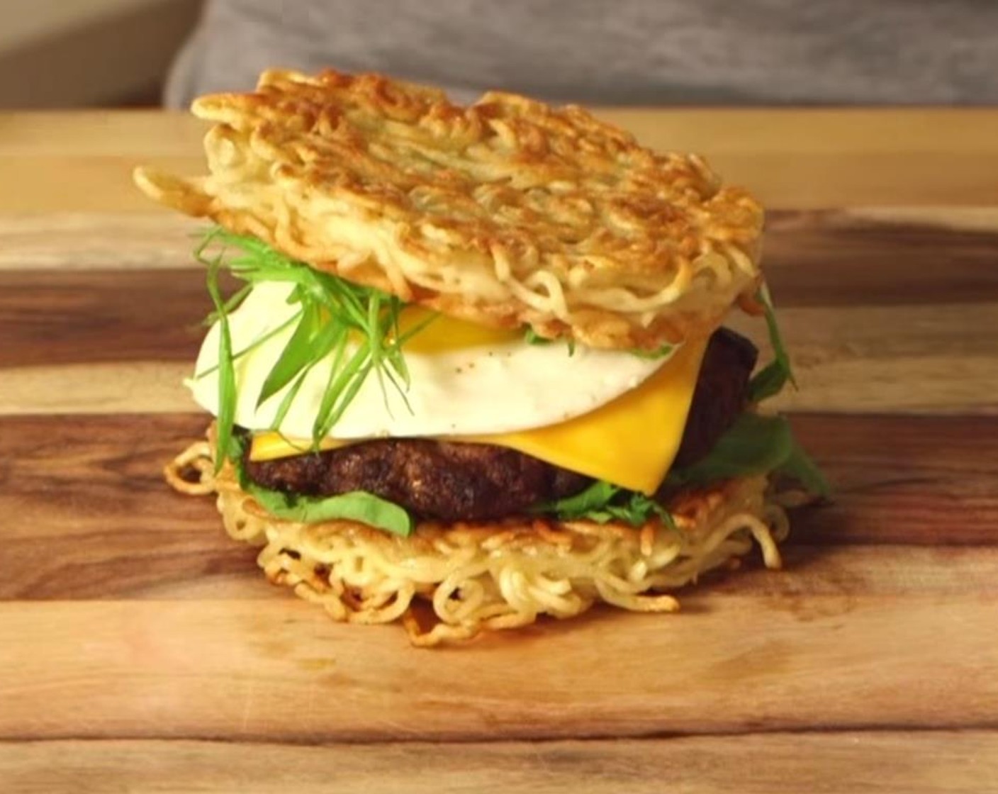 step 9 Assemble the burger in this order, ramen bun, Arugula (1/2 cup), sriracha-ketchup, burger patty, fried eggs, thinly sliced Scallion (1 bunch) and top with the other ramen bun. Wrap in wax paper for easier eating, and serve hot.