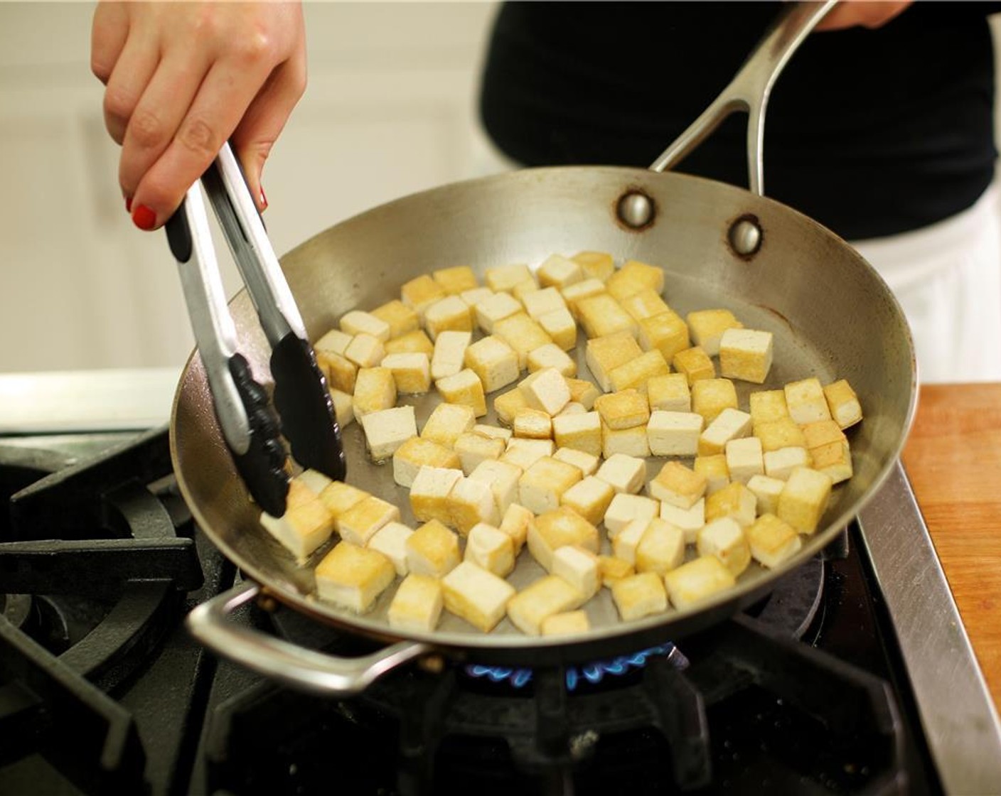 step 8 Add Olive Oil (2 Tbsp) to large saute pan over medium high heat. When oil is hot, add the super firm tofu in a single layer and saute until browned on all sides, about seven minutes.