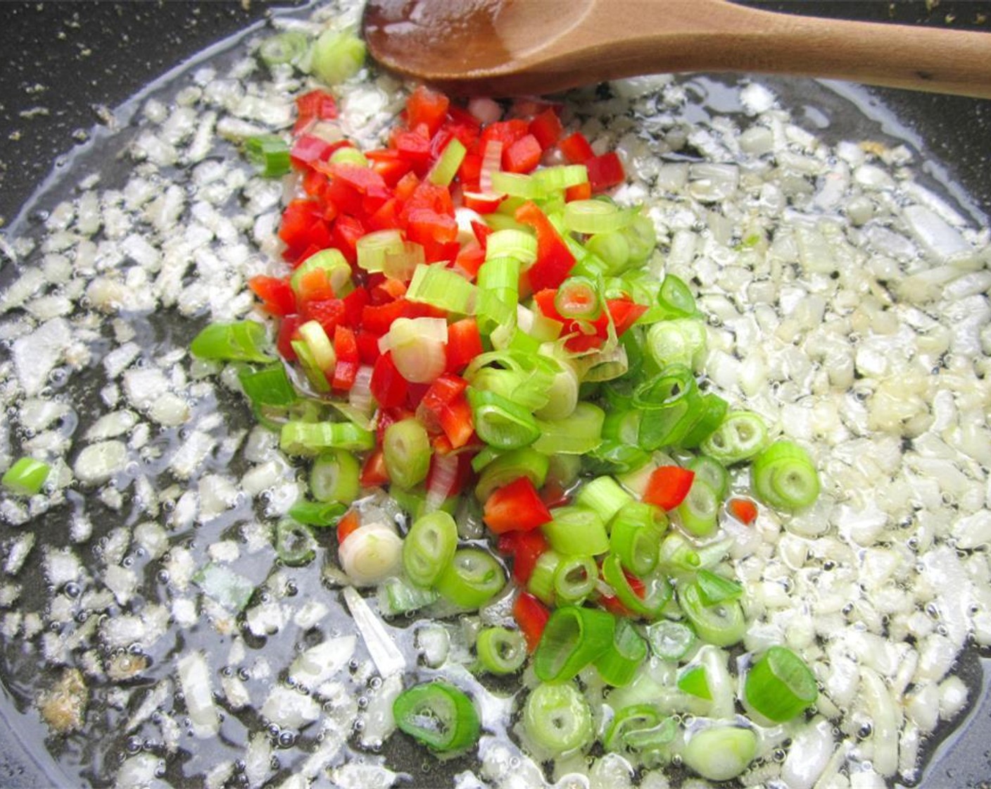 step 3 Once the diced white onion begins to soften, add the finely diced Scallion (1 bunch)  the diced Red Bell Pepper (1).