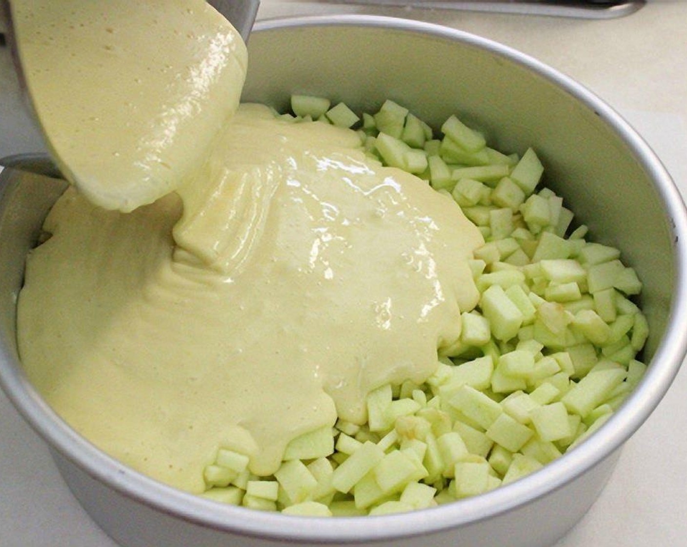 step 7 Pour the batter over the apples.