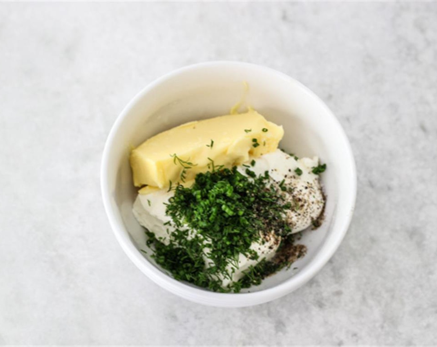 step 1 In a medium bowl, combine the Cream Cheese (1/2 cup), Butter (2 Tbsp), Fresh Dill (1 tsp), Fresh Chives (1 tsp), Salt (to taste), Ground Black Pepper (to taste), and juice from Lemon (1). Mix to combine until smooth.