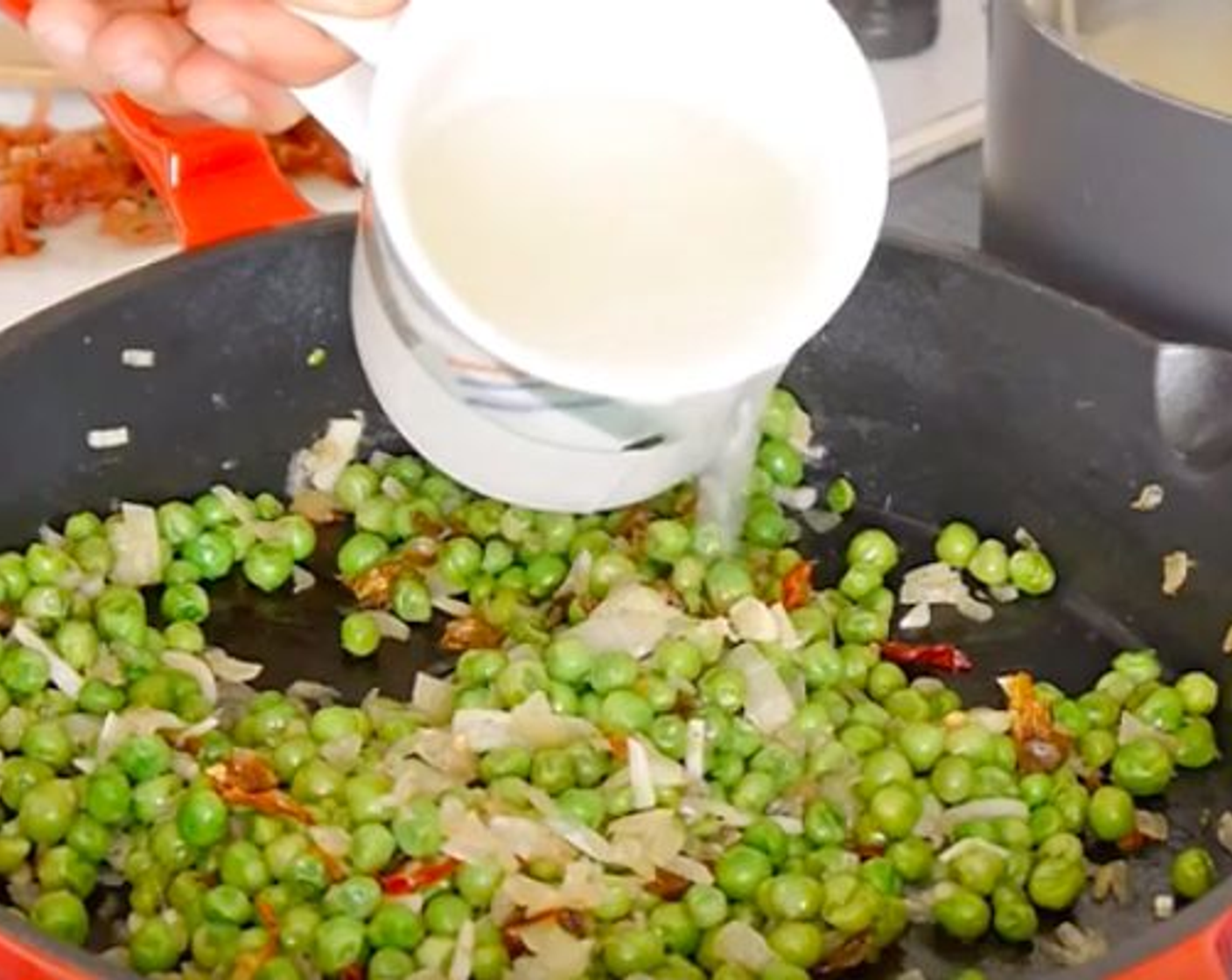 step 7 Reserve some of the pasta water in a cup and add half of it to the peas, mix and continue to cook for another 5 minutes.