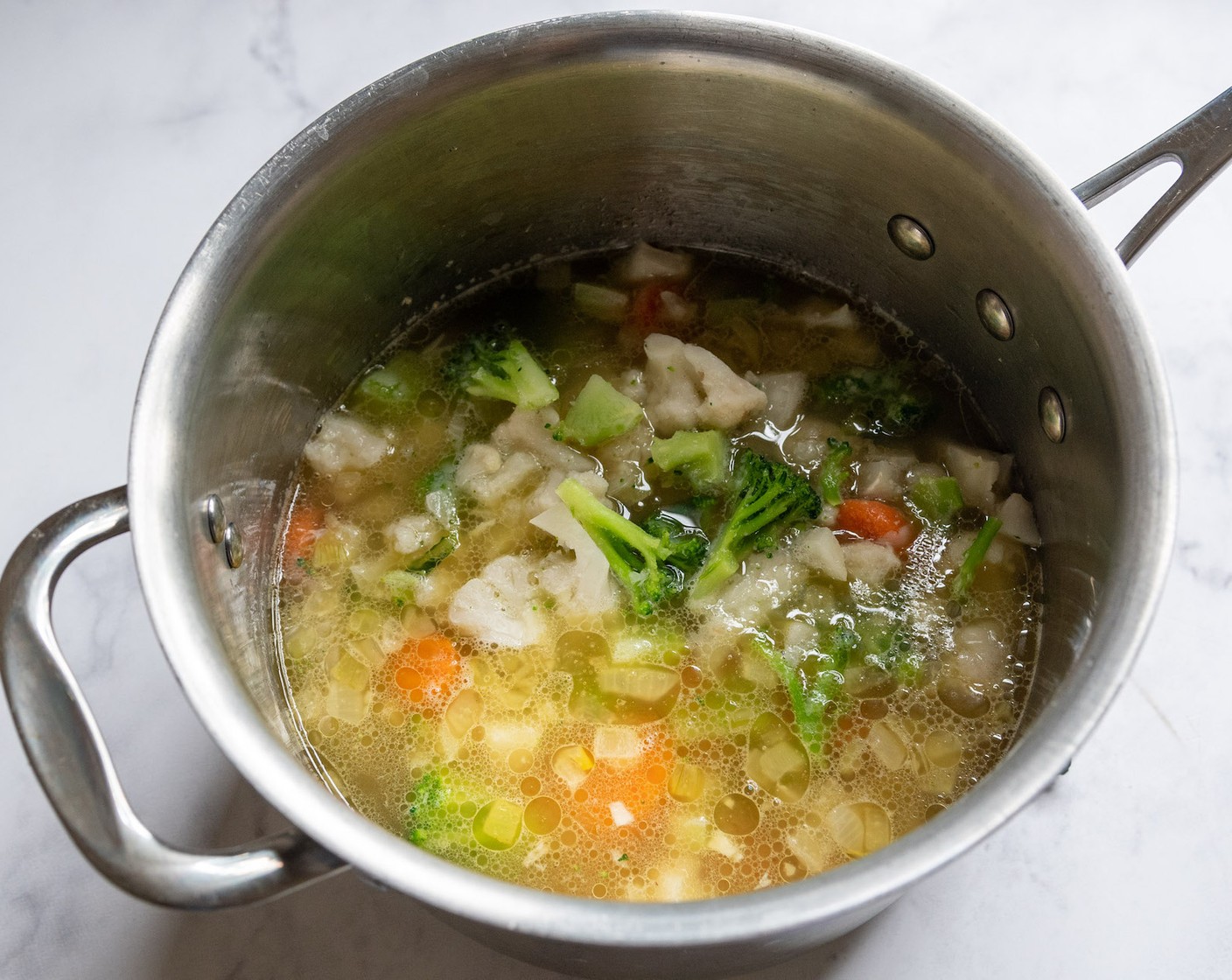 step 2 Add the Chicken Broth (3 cups), Frozen Mixed Vegetables (2 1/4 cups), Red Potatoes (1 1/2 cups), Salt (1/2 tsp), Ground Black Pepper (1/4 tsp), and Onion Powder (1/4 tsp). Raise the heat to medium-high and bring it to a boil.
