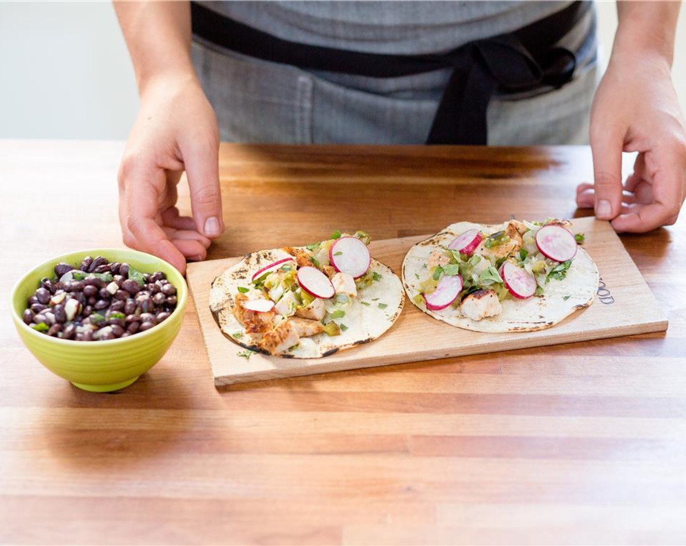 step 17 Cut the chicken into half inch diced pieces. Place a quarter of the chicken onto each tortilla. Top with tomatillo salsa, radishes, and garnish with remaining cilantro. Place the cumin black beans next to the tortillas.