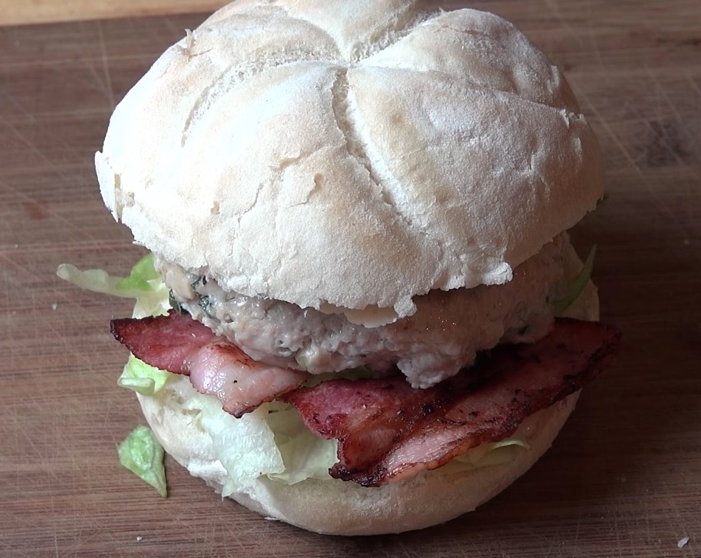 step 8 Split Soft Bread Rolls (4) in half. Pour a little bit of Caesar Dressing (to taste) on both the top and bottom halves of the roll. Top each roll with Lettuce (to taste), Bacon (to taste), chicken patty, and Parmesan Cheese (to taste).