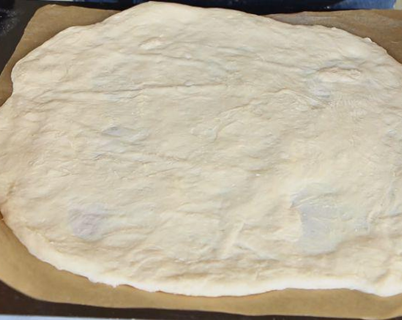 step 2 Roll out the Pizza Dough (1 lb) into a 12-13 inch diameter circle. Line a baking tray with parchment paper and preheat your oven to 450 degrees F (230 degrees C).