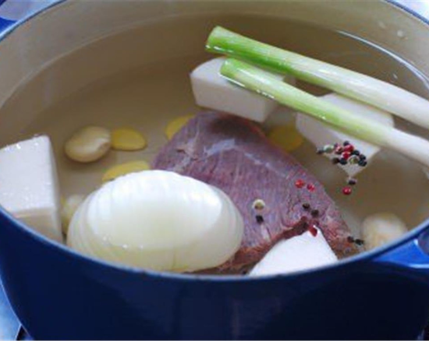 step 3 Make the broth: In a large pot, bring the Beef Brisket (8 oz), Korean Radish (6 oz), Onion (1/2), the white part of the Scallion (1 bunch), Garlic (6 cloves), Fresh Ginger (3 slices), and Peppercorns (1/2 tsp) to a boil, uncovered, in 14 cups of water.