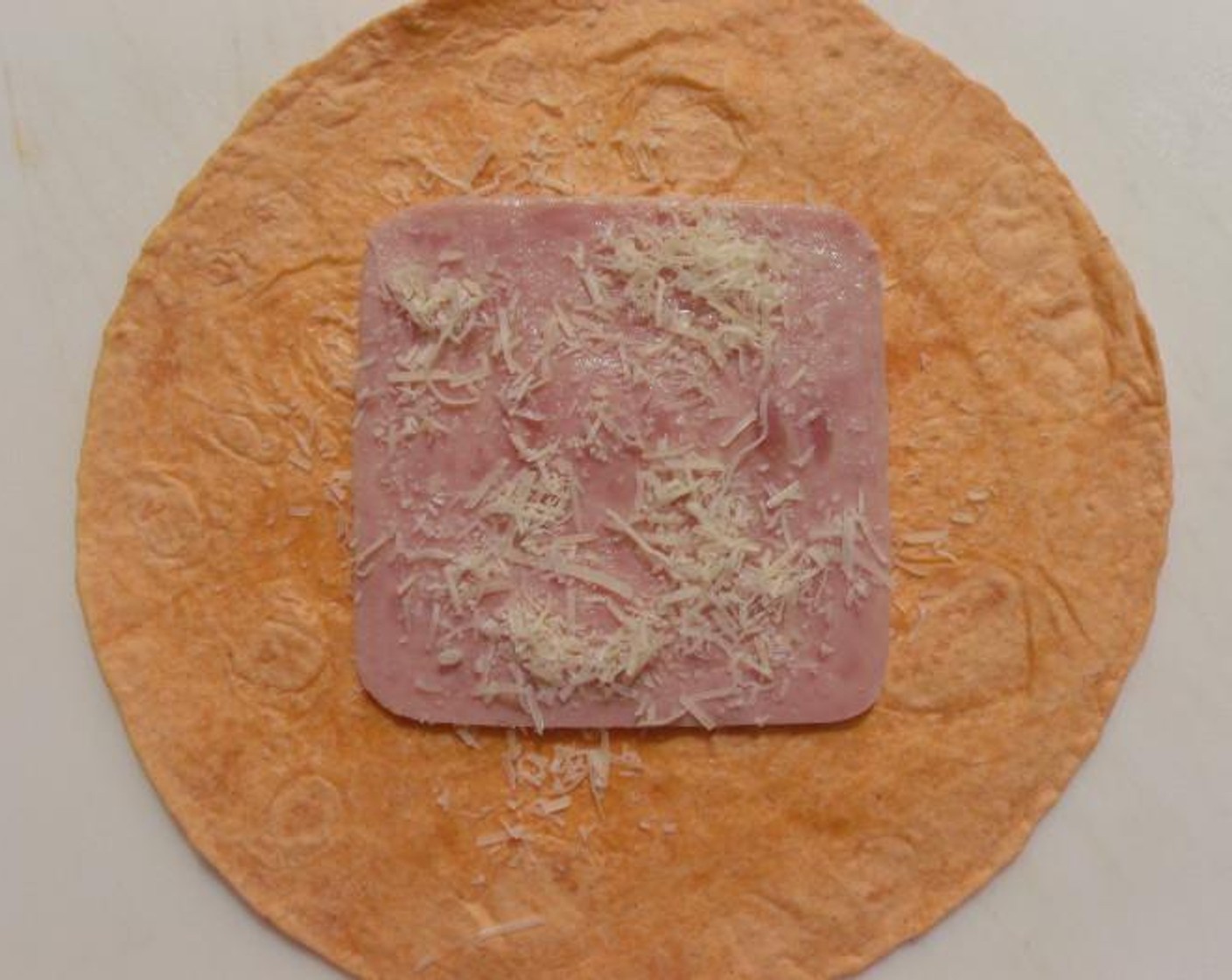 step 2 Top with Cooked Ham (1 slice) and sprinkle with Grated Parmesan Cheese (1 pinch).