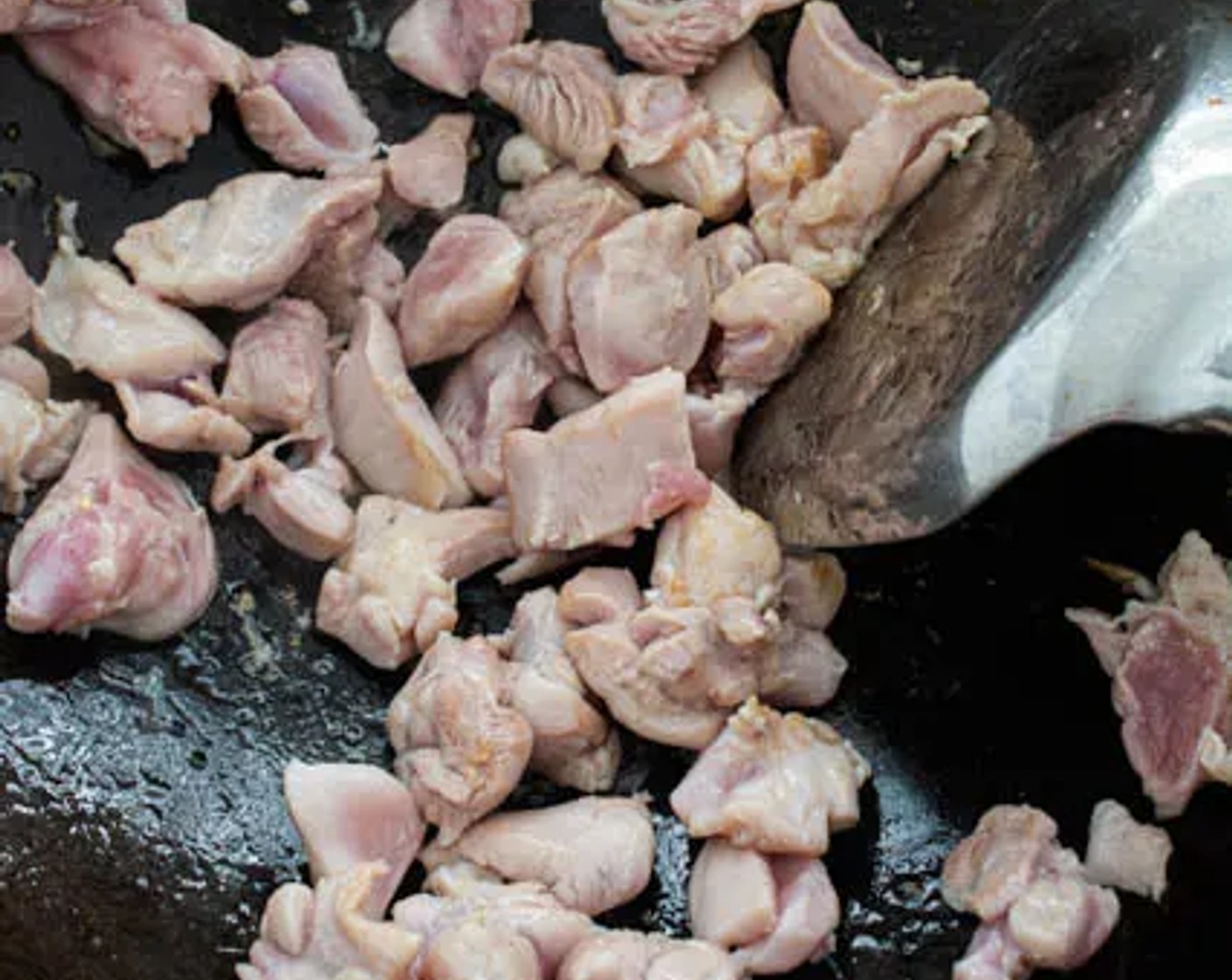 step 3 Heat Cooking Oil (2 Tbsp) in a wok over medium-high heat. Add Boneless, Skinless Chicken Thighs (2) to the wok in a single layer. Allow the chicken to sear for about 30 seconds, then stir.