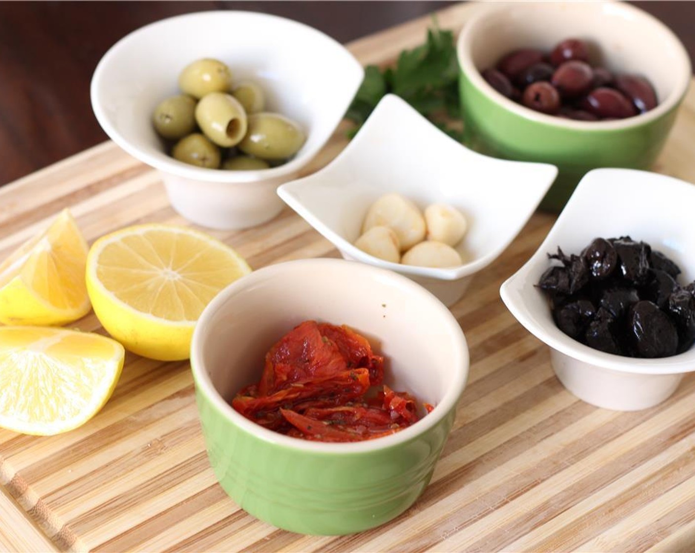 step 1 Prepare your ingredients: measure the Kalamata Olives (1/2 cup), Green Olives (4 Tbsp), Beldi Olives (4 Tbsp), and Roasted Tomatoes (4 Tbsp) and peel the Garlic (2 cloves).