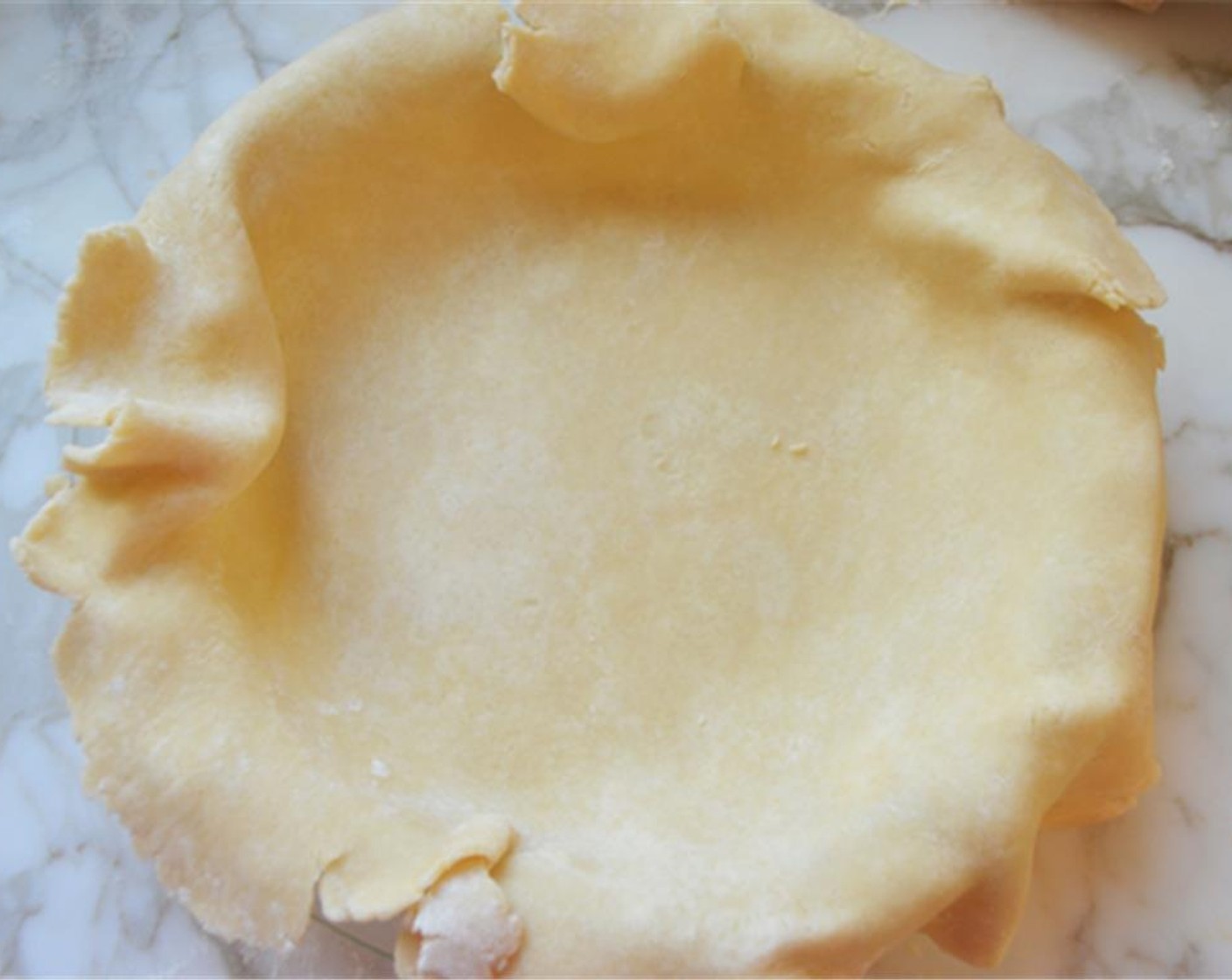 step 6 Roll the dough into a 14-inch circle. Carefully drape the dough over the rolling pin and transfer it to a 9-inch​ deep-dish​ pie pan (should be at least 1 1/2 inches deep). Gently fit the dough into the pan by easing it inwards. If it tears, patch it right back up.