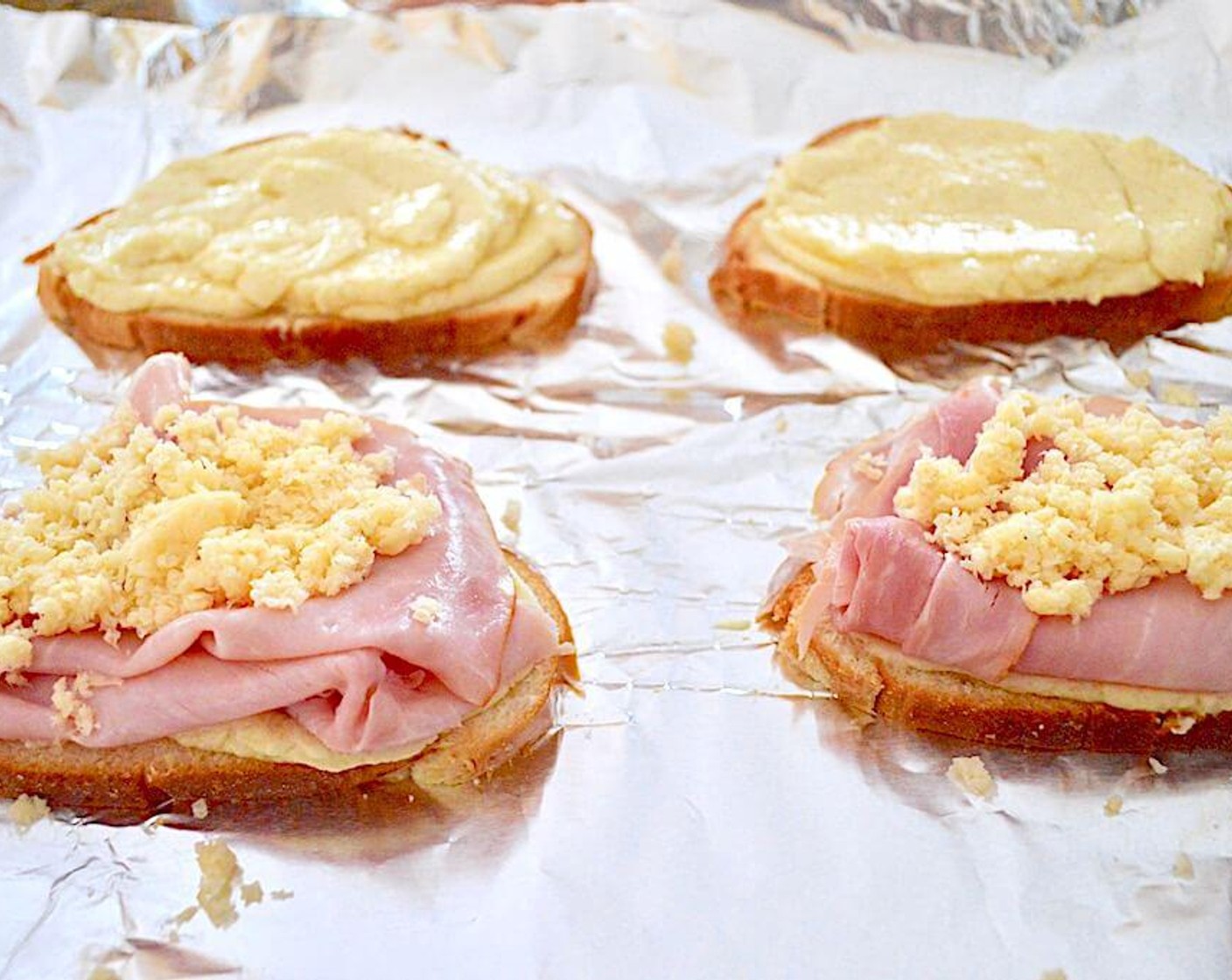 step 4 Lay out the Brioche (4 slices) on the sheet pan and spread 1/4 of the béchamel sauce onto each slice. Nestle two slices of Smoked Deli Ham (4 slices) into the béchamel sauce on two of the slices. Then take half of the Smoked Gouda (3/4 cup) and evenly divide it on top of the ham. Place the other two slices of bread on top with the béchamel side up and evenly divide the remaining cheese on top of that.