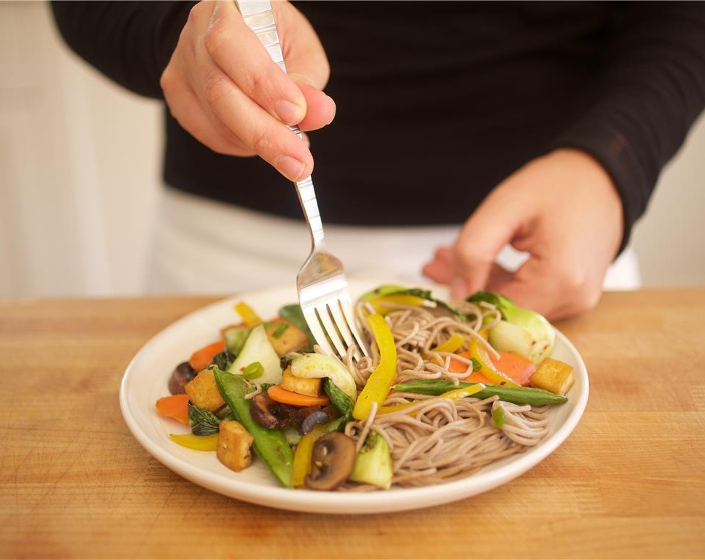 step 12 Place soba noodles in the center of two plates. Top with the tofu and vegetable mixture.