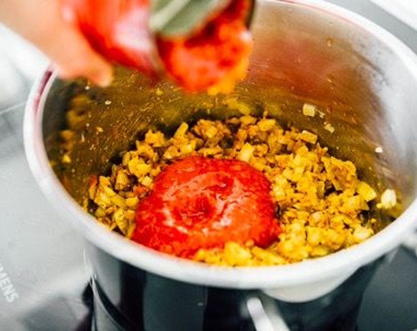 step 2 Add Crushed Tomatoes (1 can), Coconut Milk (1 can), and Red Kidney Beans (1 can), bringing to a gentle simmer to warm everything.