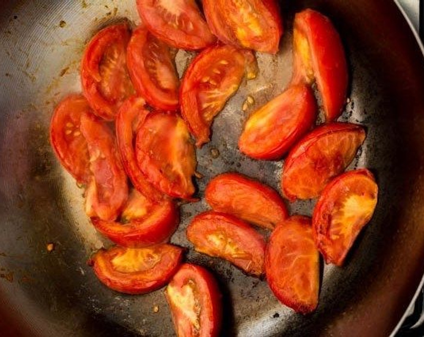 step 3 Add Cooking Oil (1 Tbsp) to the hot wok, then add the Tomatoes (2). Allow the tomatoes to char slightly for about 30 seconds, then flip them over.